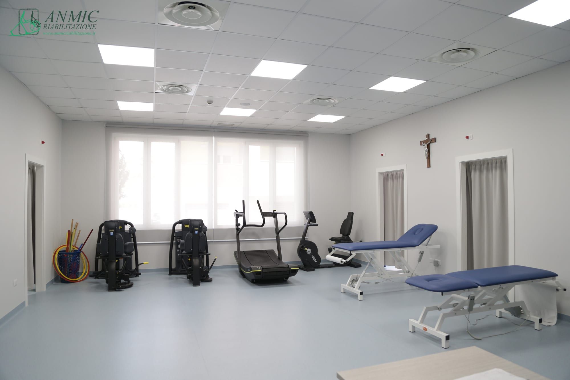 Palestra riabilitativa ampia e luminosa con macchinari, cyclette e lettino di trattamento