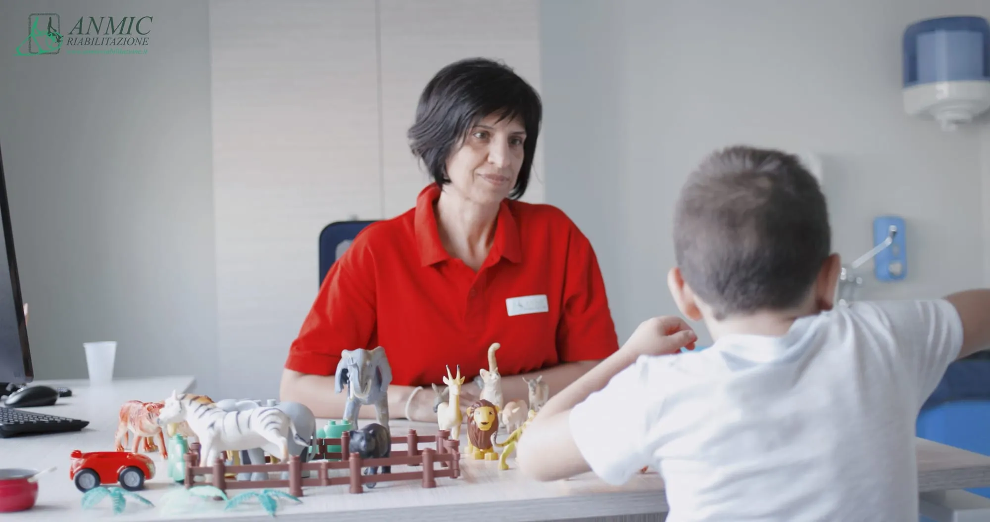 Terapista al lavoro con un bambino durante un'attività di riabilitazione